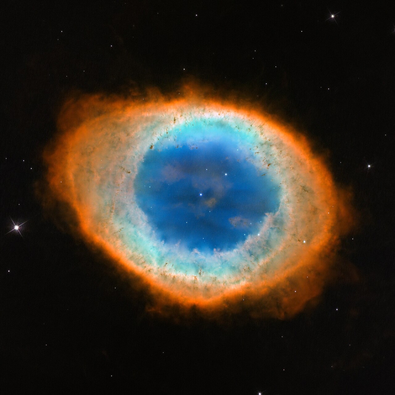 ハッブル宇宙望遠鏡が写した環状星雲(メシエ57)で、地球からは単純な楕円形に見えます。環状星雲は、年老いた星が噴き出したガスが光る惑星状星雲のひとつで、真ん中の星はやがて白色矮星になります。